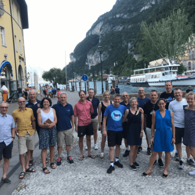 Cycling group walking on the shores of Lake Garda on their way to dinner