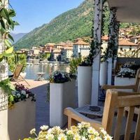 View of Lake Como hotel Velo Tours use from deck of hotel room overlooking the water with flower pots and Italian buildings on lake shore