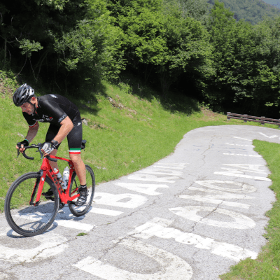 Cyclist riding up very steep section of the Wall of Sormano, famous climb of Il Lombardia race